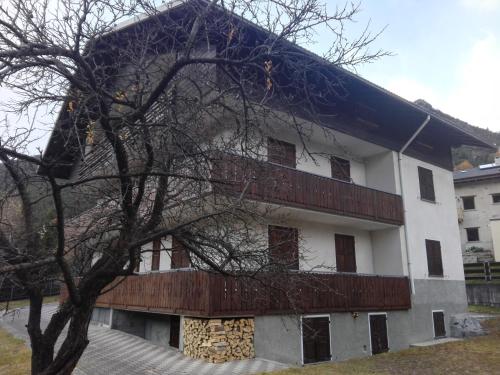 a white building with a tree in front of it at Chalet Bianco in Valdidentro