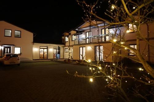 a house at night with lights in front of it at Hotel-Pension Pastow Garni in Broderstorf