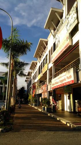 a building with a palm tree in front of a street at Myera Hotel in Banting
