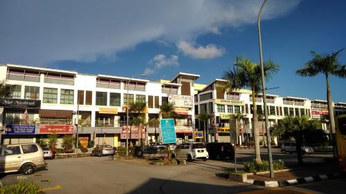 a large white building with cars parked in a parking lot at Myera Hotel in Banting