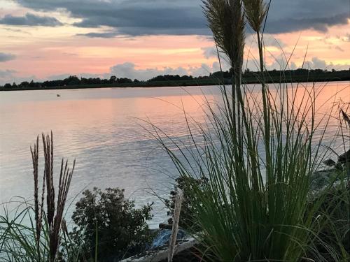 a view of a body of water at sunset at Vakantie Villa Markermeer in Bovenkarspel
