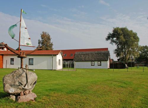 ロープベにあるFerienhaus mit Reetdach am Lobberの庭の岩と尖塔を持つ教会