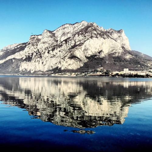 a mountain reflecting in a body of water at Casa Sull'Albero in Malgrate