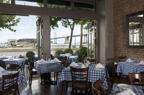 een restaurant met blauwe en witte tafels en ramen bij Hotel Griffon in San Francisco
