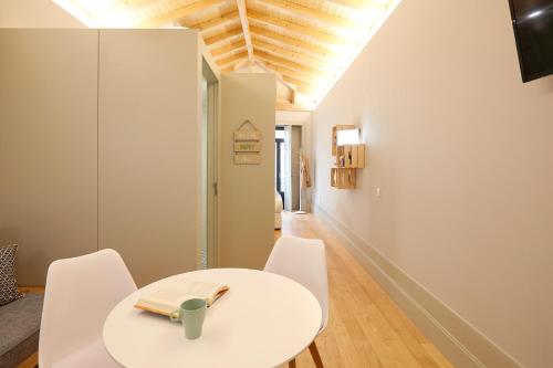 a white dining room with a white table and chairs at LOFT Sá de Noronha in Porto