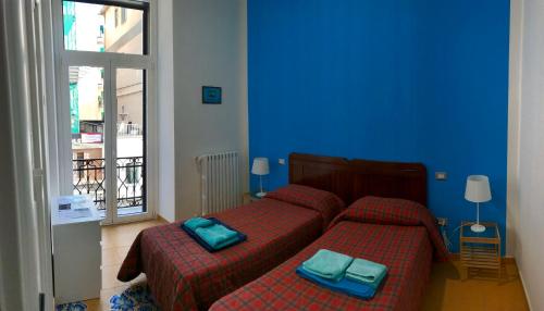 una camera da letto con un letto con due asciugamani blu sopra di B&B Le Marinelle a Salerno