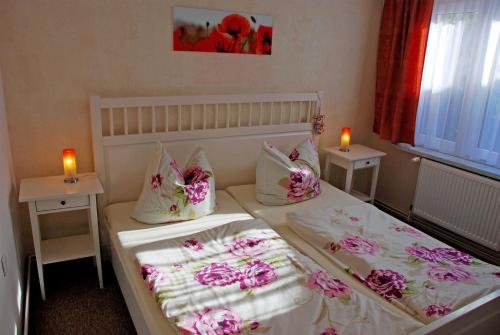 a bedroom with two beds with pink flowers and candles at Ferienwohnungen am Heideweg in Baabe