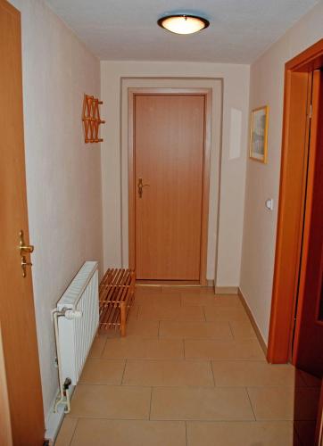 a hallway with a wooden door and a staircase at Ferienwohnungen am Heideweg in Baabe