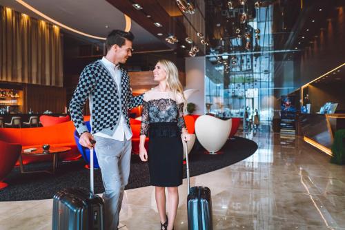 a man and woman standing with luggage in a lobby at Atlantida Boutique Hotel in Rogaška Slatina