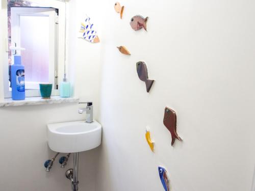 a bathroom with a sink and fish magnets on the wall at Casa Almagio - Atrani Amalfi coast - terrace & seaview in Atrani