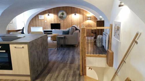 cocina y sala de estar con arco en Maison à Tour Briançon en Briançon