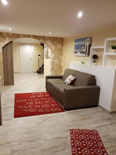 a living room with a couch and a red rug at La nassa fitta camere in Brindisi