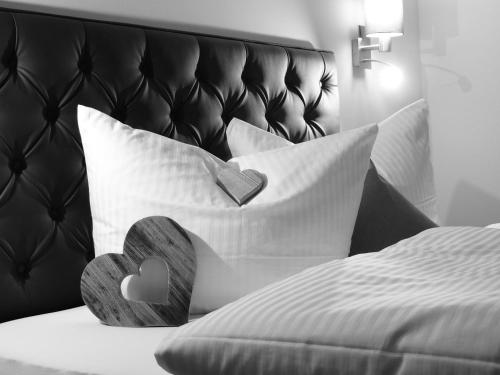 a bed with white pillows and a black head board at Buttererhof-Apartments in Fulpmes