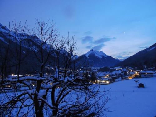 a view of a town in the snow at night at Buttererhof-Apartments in Fulpmes