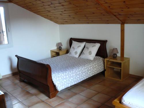a bedroom with a bed with two night stands and two lamps at Appartement dans maison Entre Savines et Embrun in Crots