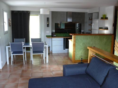 CrotsにあるAppartement dans maison Entre Savines et Embrunのテーブルと椅子、キッチンのあるリビングルーム