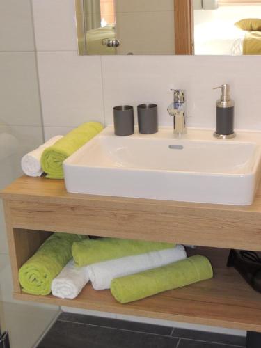 a bathroom with a sink and towels on a shelf at Buttererhof-Apartments in Fulpmes
