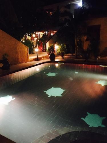a swimming pool at night with lights in it at Maison Couleur Passion in Nianing