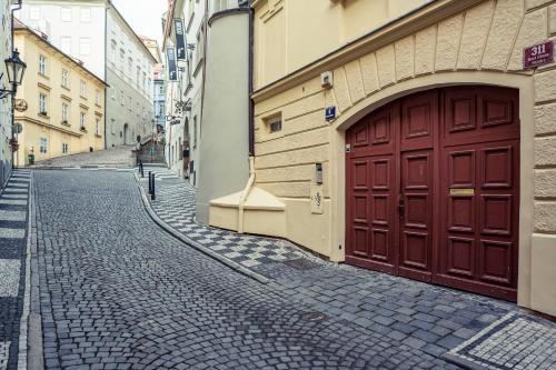 a cobblestone street with a red door on a building at St. George Apartments in Prague
