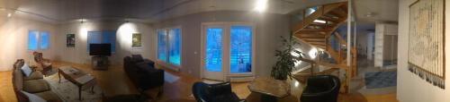 a living room with a staircase and a table and chairs at Talvitaival Apartments in Varkaus