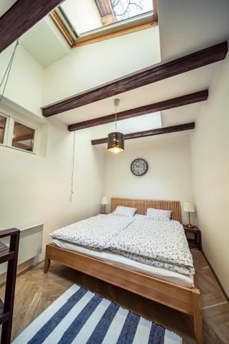 a bedroom with a bed and a clock on the wall at St. George Apartments in Prague