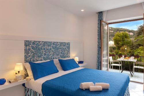 a bedroom with a blue bed and a balcony at Casa Aurora in Sorrento