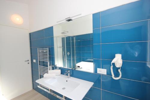 a blue bathroom with a sink and a mirror at Ville D'Ogliastra in Cardedu