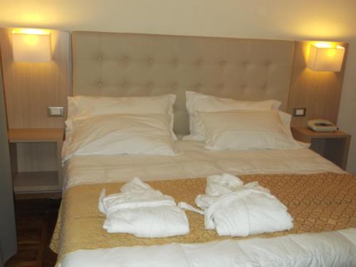 a bed with two towels on top of it at Hotel Villa Maria in Sanremo