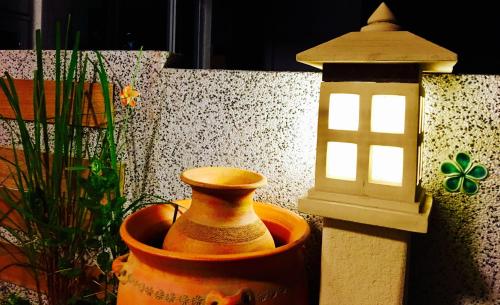 an orange vase sitting next to a bird house at Home & Teak Homestay in Jinning