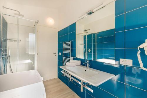 a blue and white bathroom with a sink and a tub at Ville D'Ogliastra in Cardedu