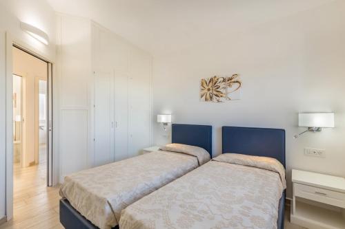 two beds in a bedroom with white walls at Ville D'Ogliastra in Cardedu