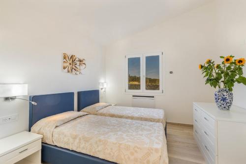 a bedroom with a bed and a vase of flowers at Ville D'Ogliastra in Cardedu