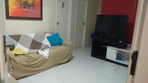 a living room with a couch and a flat screen tv at Casa na Aruana Aracajú-SE in Aracaju