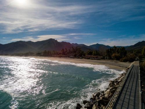 a beach with a wooden walkway next to the water at Ville D'Ogliastra in Cardedu