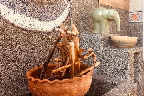 a wooden planter with wooden sticks in a wall at Home & Teak Homestay in Jinning