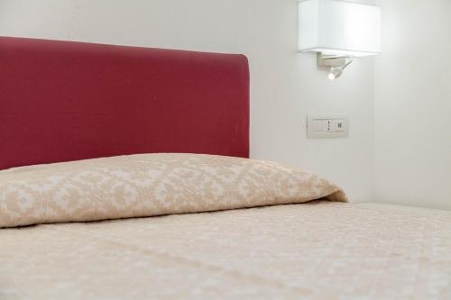 a bed with a pillow on it in a room at Ville D'Ogliastra in Cardedu