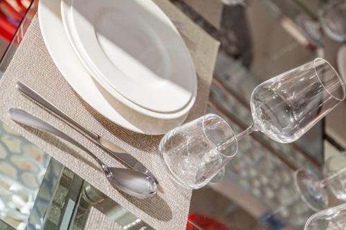 a table with two glasses and a plate and spoon at Ville D'Ogliastra in Cardedu