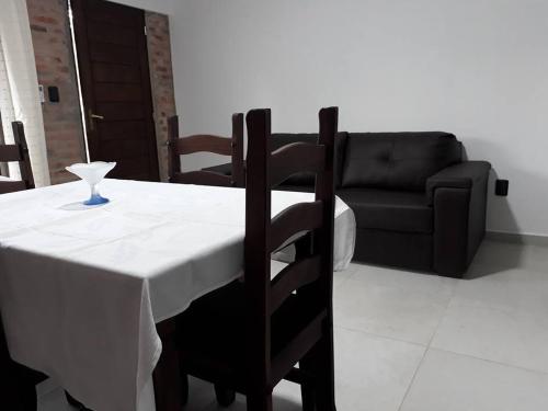 une table avec un chiffon de table blanc et un canapé noir dans l'établissement Los Cardenales, à Santa Ana