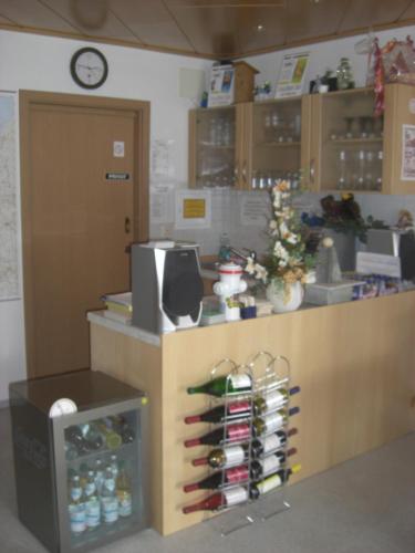 a store with a counter with bottles and a clock at Pension Beer in Mähring