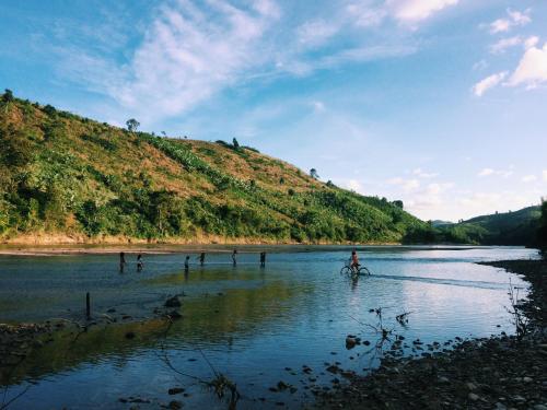 a person riding a bike in the water at Vietnam Phuot Real Home in Kon Tum