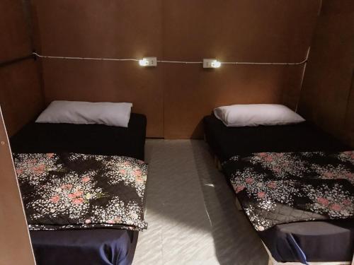 a room with two beds in a room with at HostelBed @ Phitsanulok in Phitsanulok
