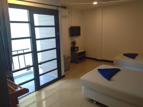 a bedroom with two beds and a sliding glass door at Phi Phi Inn in Phi Phi Islands