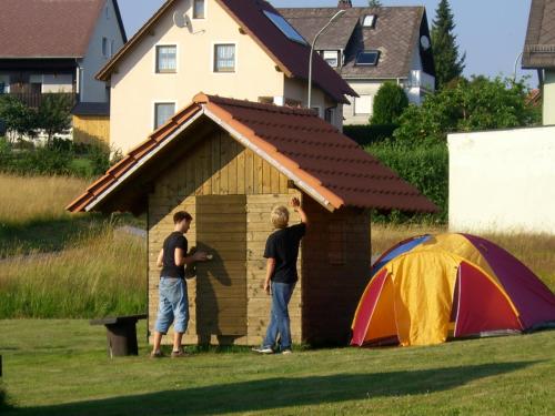 two men standing in a dog house with a tent at Pension Beer in Mähring