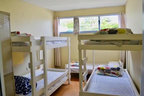 a room with three bunk beds and a window at Apollo Bay Backpackers in Apollo Bay
