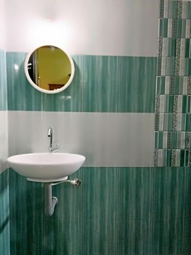 a bathroom with a sink and a mirror at shirley's guest house in Majorda