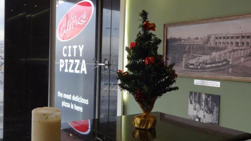 a christmas tree in a vase on a table at Hotel Halwachy in As Sulaymānīyah