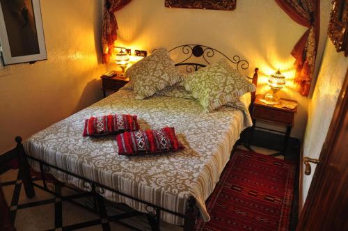 a bedroom with a bed with two pillows on it at Dar Aliane in Fès