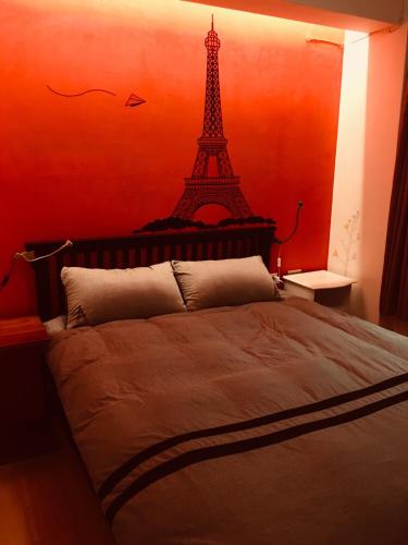 a bedroom with a bed with a eiffel tower on the wall at Corner Inn九份住宿I 小角落民宿I 機車租借I日夜間導覽 in Jiufen