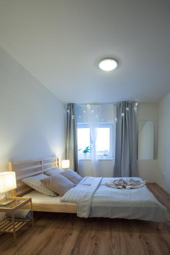 a bedroom with a large bed and a window at Haas Apartments Stojanova with Parking in Brno