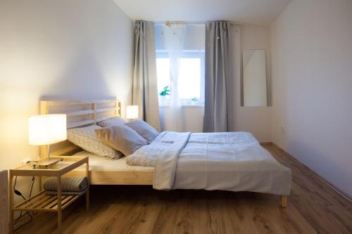 a bedroom with a bed and a window at Haas Apartments Stojanova with Parking in Brno